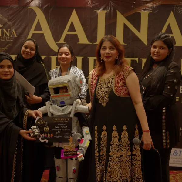 Exhibitor and guests with the AAINA 2026 backdrop