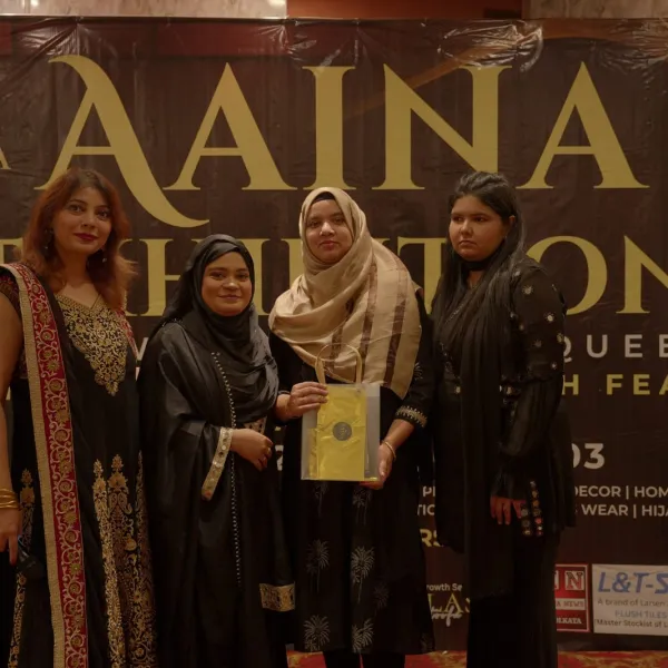 An exhibitor receives her certificate at AAINA 2026