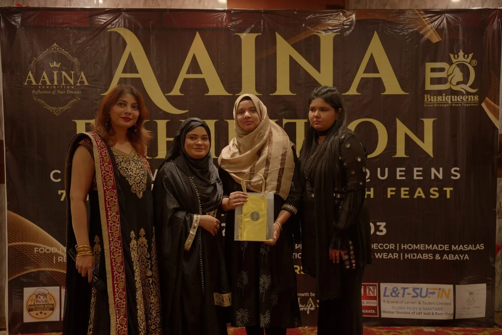 An exhibitor receives her certificate at AAINA 2026, a Busiqueens exhibition in Kolkata